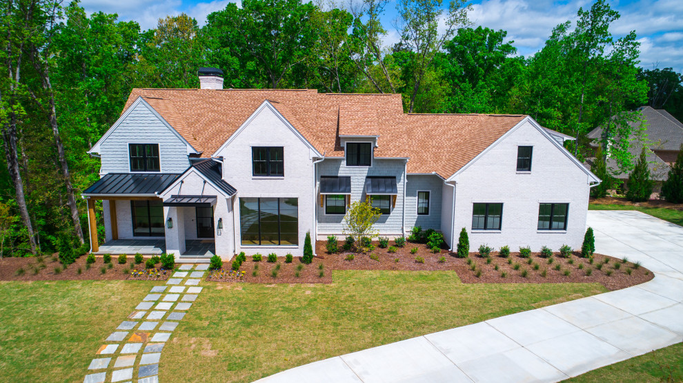 This is an example of a large and white farmhouse two floor brick detached house in Atlanta with a pitched roof and a mixed material roof.