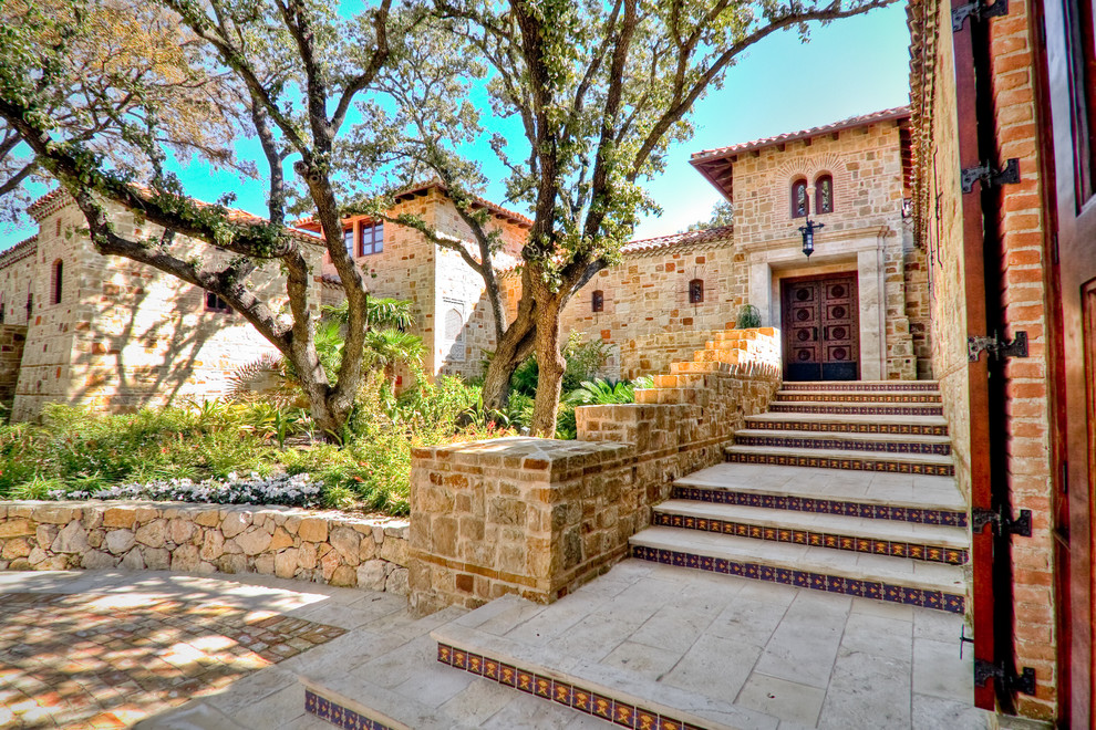 Inspiration for a mediterranean house exterior in Austin with stone cladding.