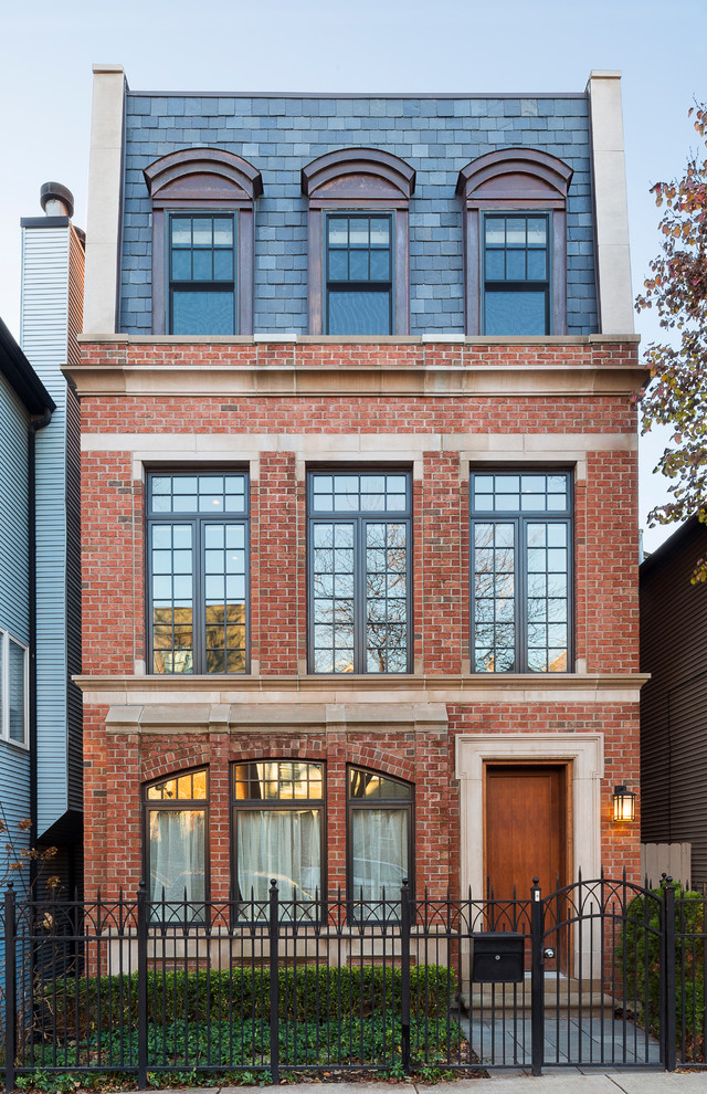 Photo of a large and red traditional brick terraced house in Chicago with three floors, a flat roof and a shingle roof.