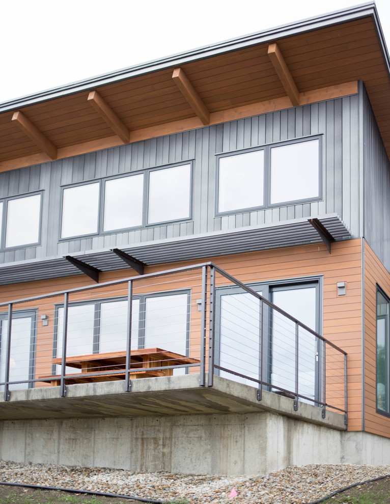 Cette photo montre une grande façade de maison marron moderne en bois à deux étages et plus.