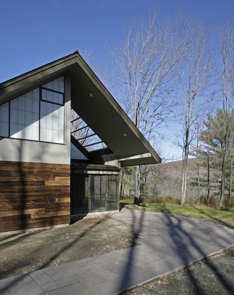 This is an example of a medium sized and gey modern bungalow house exterior in New York with mixed cladding.
