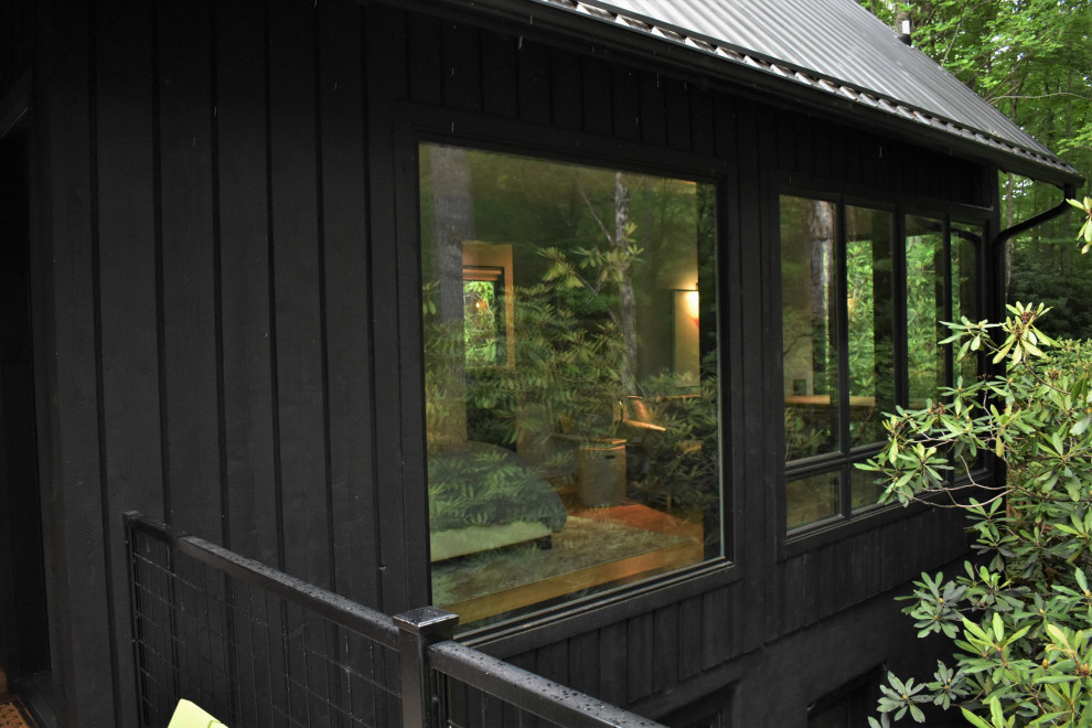 Inspiration för ett mellanstort funkis svart hus, med två våningar, sadeltak och tak i metall