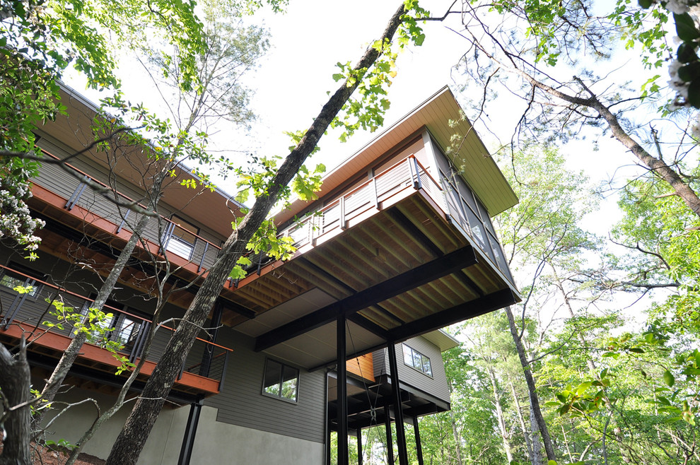 Idée de décoration pour une façade de maison grise chalet en bois de taille moyenne et à un étage avec un toit plat.