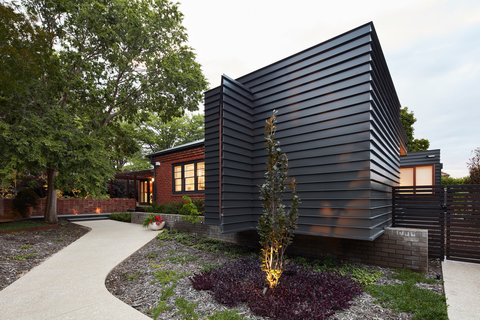 Идея дизайна: одноэтажный, черный частный загородный дом среднего размера в современном стиле с облицовкой из металла, плоской крышей и металлической крышей