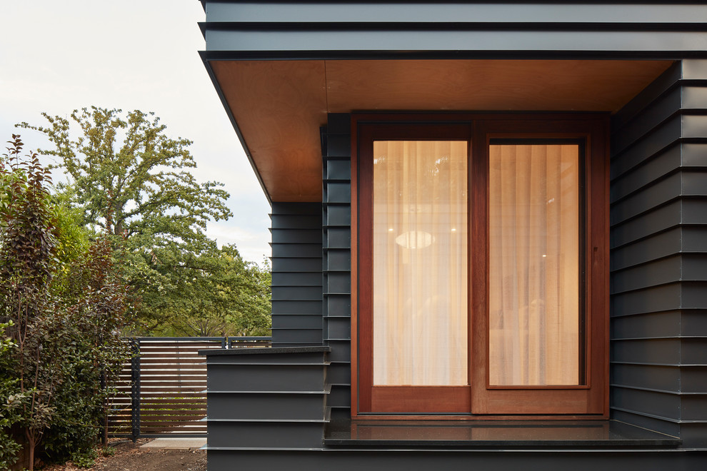 Photo of a medium sized and black contemporary bungalow detached house in Canberra - Queanbeyan with metal cladding, a flat roof and a metal roof.