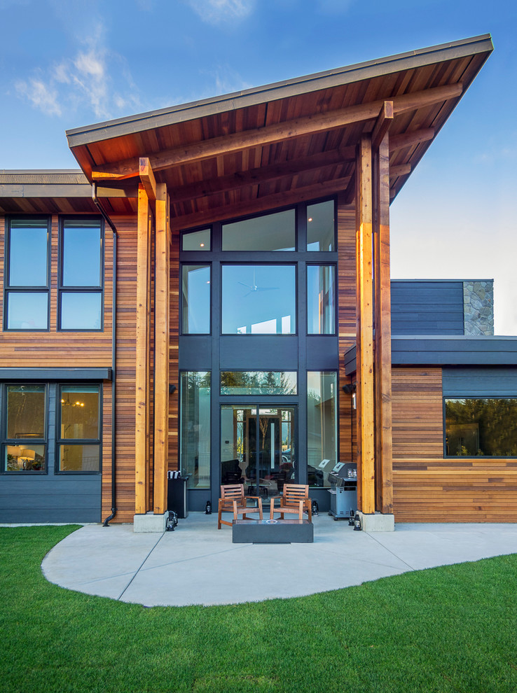 Idées déco pour une façade de maison grise contemporaine en bois avec un toit en appentis et un toit en métal.