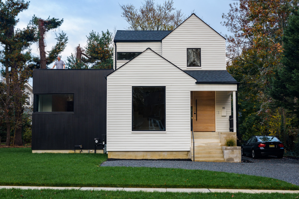 Идея дизайна: маленький, двухэтажный, черный частный загородный дом в стиле модернизм с облицовкой из ЦСП, двускатной крышей и крышей из смешанных материалов для на участке и в саду