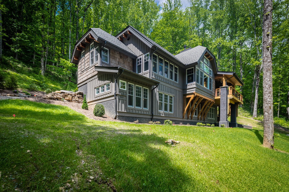 На фото: большой, двухэтажный, деревянный, серый частный загородный дом в стиле рустика с вальмовой крышей