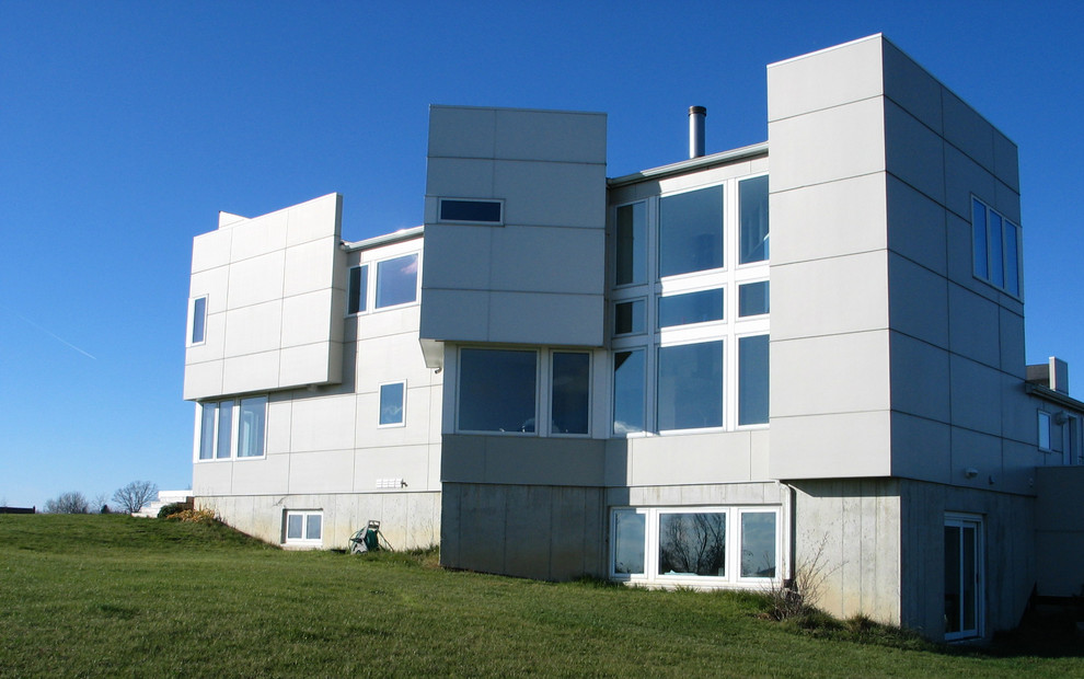 Modelo de fachada beige moderna de tamaño medio de dos plantas con revestimiento de aglomerado de cemento y tejado a dos aguas