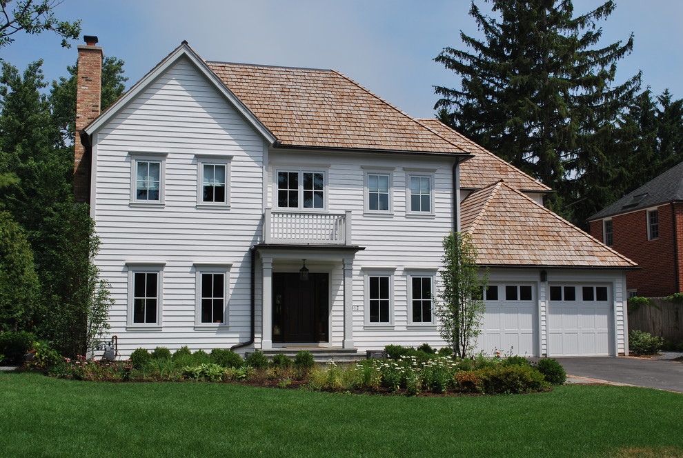 Cette photo montre une façade de maison blanche chic en bois à un étage avec un toit à deux pans.