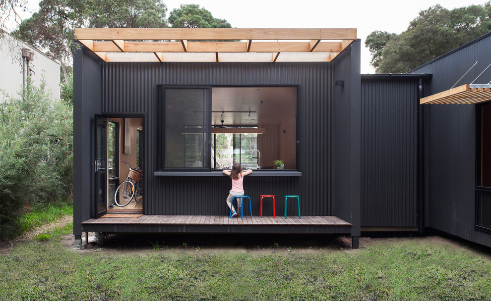 Medium sized and gey contemporary house exterior in Melbourne with metal cladding and a flat roof.