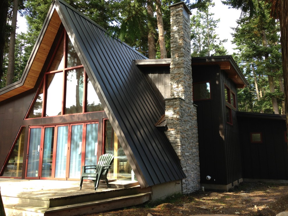 This is an example of a medium sized and black rustic two floor house exterior in Seattle with wood cladding.