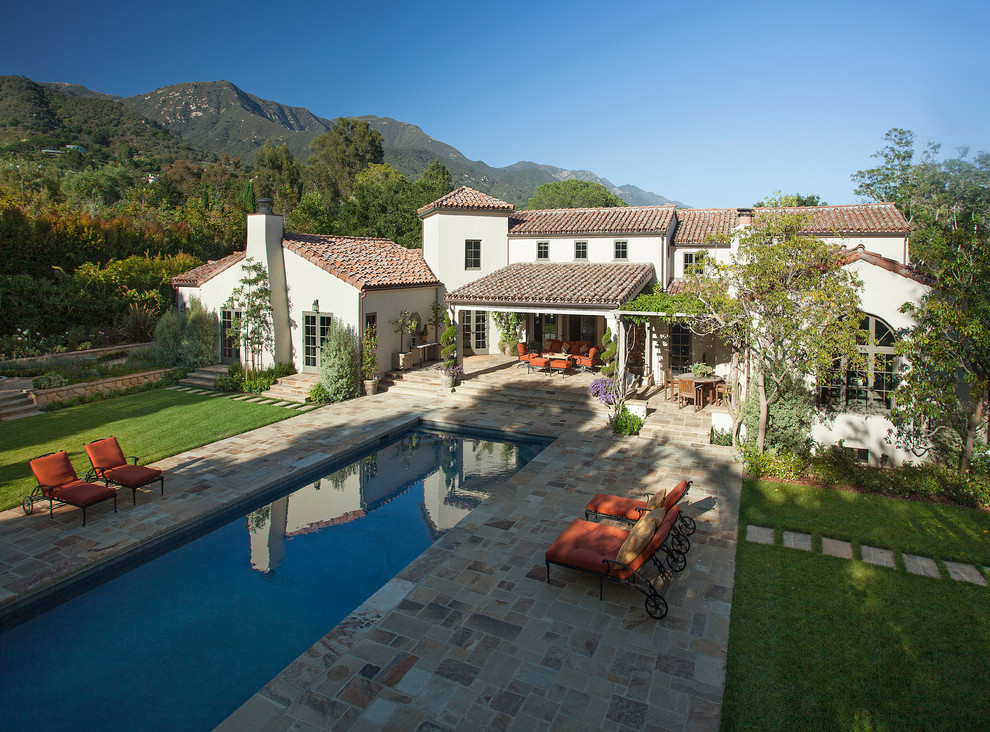 This is an example of a white mediterranean two floor house exterior in Santa Barbara.