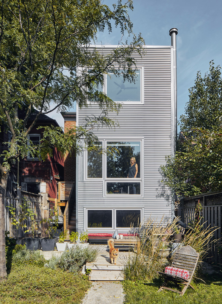 Urban house exterior in Toronto with three floors, metal cladding and a flat roof.