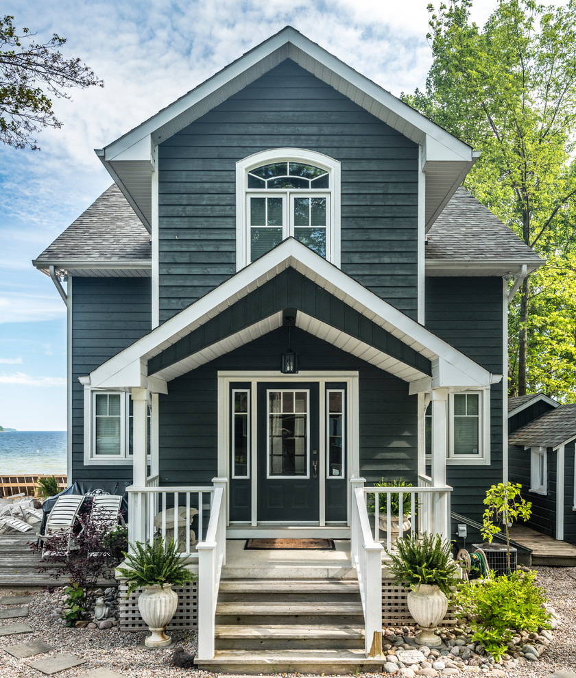На фото: двухэтажный, деревянный, синий дом среднего размера в морском стиле