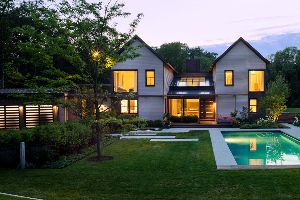 Inspiration pour une grande façade de maison beige design à un étage avec un revêtement mixte, un toit à deux pans et un toit en shingle.