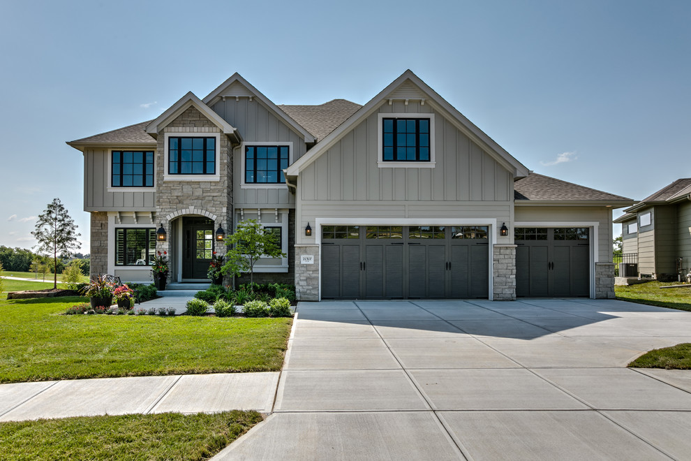 Exemple d'une grande façade de maison grise chic en béton à un étage avec un toit à deux pans et un toit en shingle.