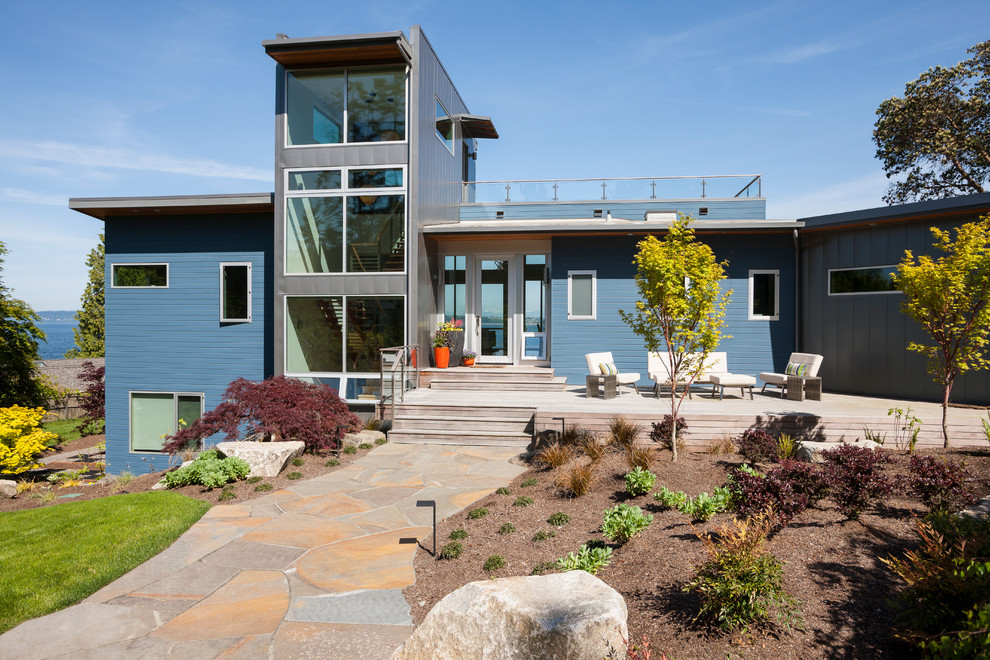 Großes, Dreistöckiges Modernes Einfamilienhaus mit Mix-Fassade, blauer Fassadenfarbe, Pultdach und Blechdach in Seattle