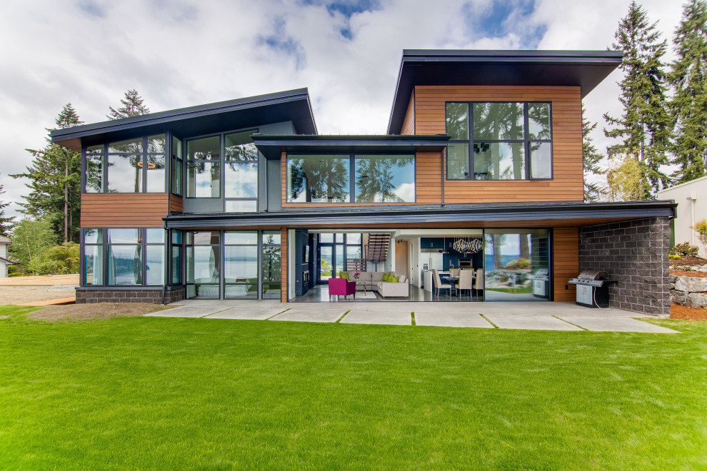 Ispirazione per la facciata di una casa moderna a due piani di medie dimensioni con rivestimento in legno e copertura in metallo o lamiera
