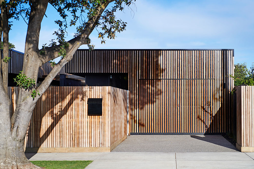 Cette photo montre une façade de maison marron bord de mer en bois de plain-pied avec un toit plat.