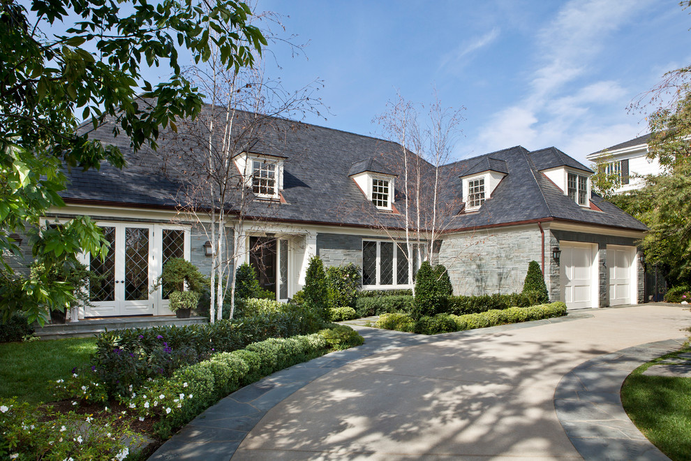 Example of a large classic gray two-story stone exterior home design in Los Angeles with a tile roof