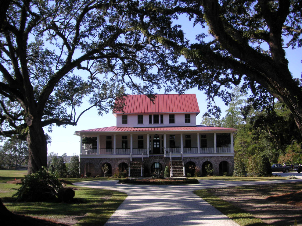 Idee per la facciata di una casa grande bianca tropicale a due piani con rivestimento in legno e tetto rosso