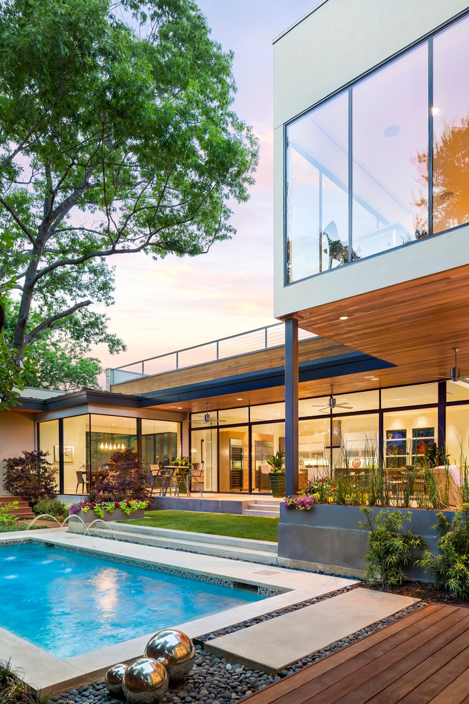 This is an example of a small contemporary two floor glass house exterior in Dallas.