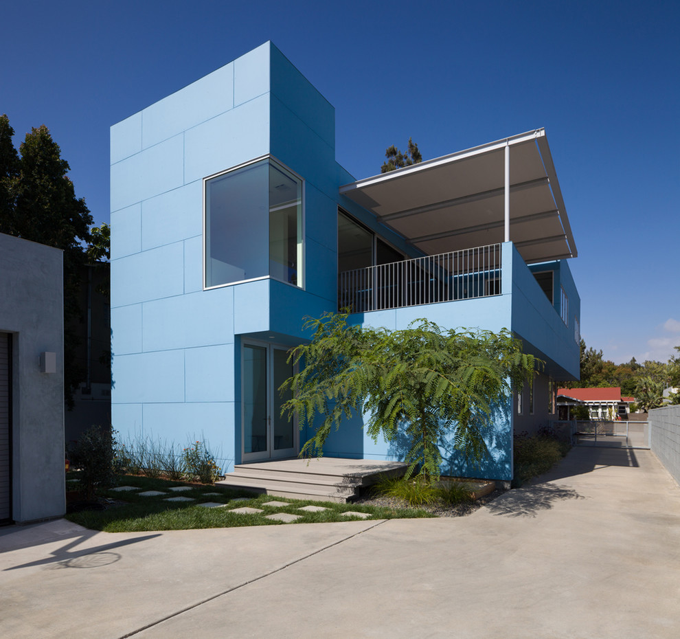 Inredning av ett modernt mellanstort blått hus, med två våningar, fiberplattor i betong och platt tak