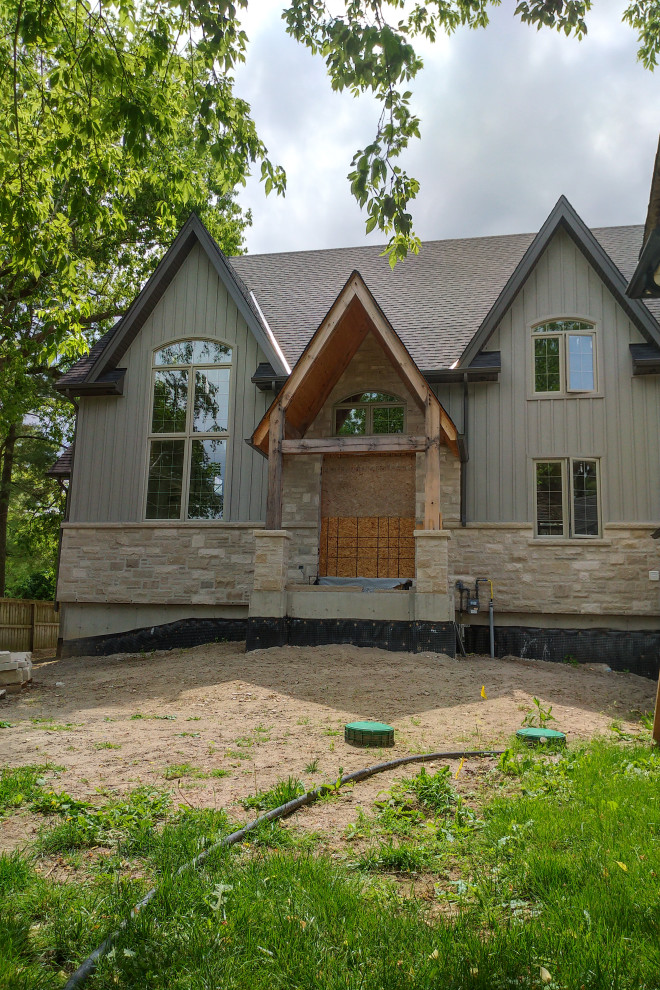 This is an example of a gey traditional two floor detached house in Toronto with wood cladding and a shingle roof.