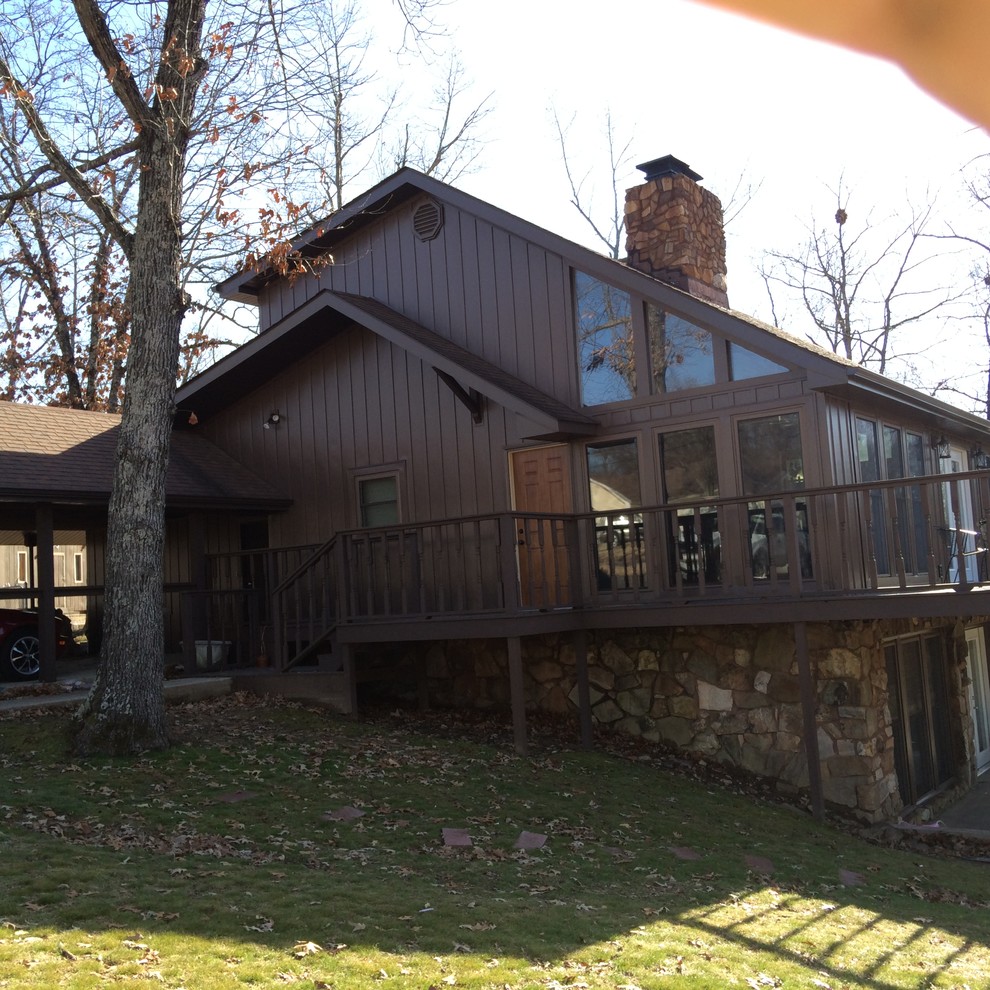 На фото: большой, трехэтажный, коричневый дом в стиле рустика с облицовкой из металла и двускатной крышей с