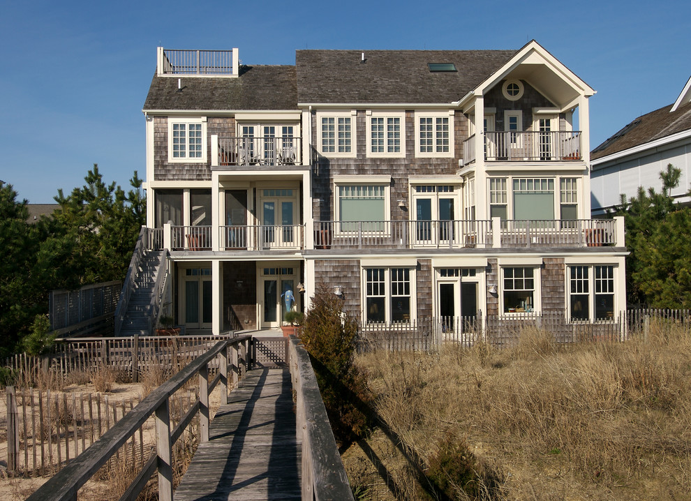 Inspiration pour une grande façade de maison grise traditionnelle en bois à deux étages et plus.