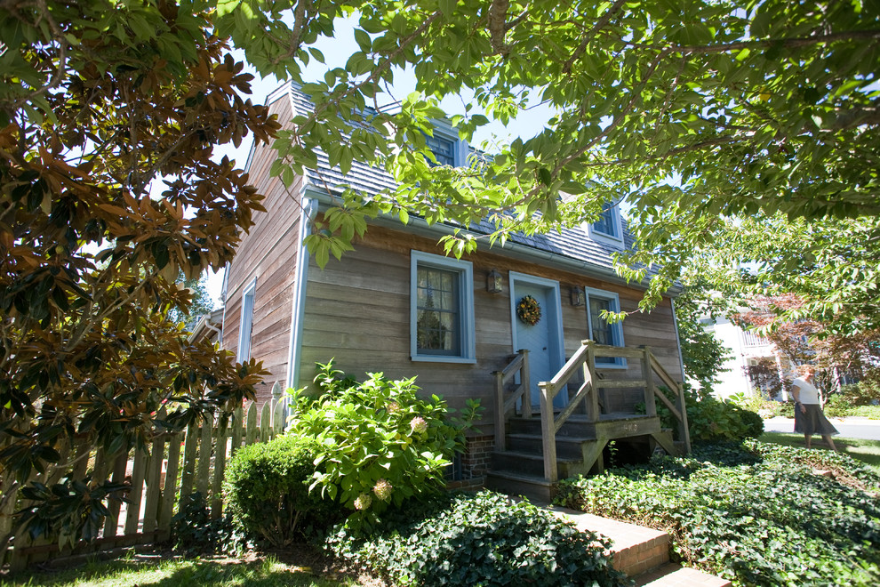 Cette photo montre une façade de maison grise chic en bois à un étage et de taille moyenne avec un toit en appentis.