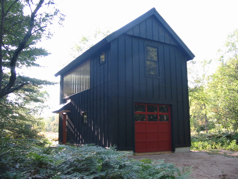 На фото: двухэтажный, деревянный, черный, маленький дом в стиле модернизм с двускатной крышей для на участке и в саду