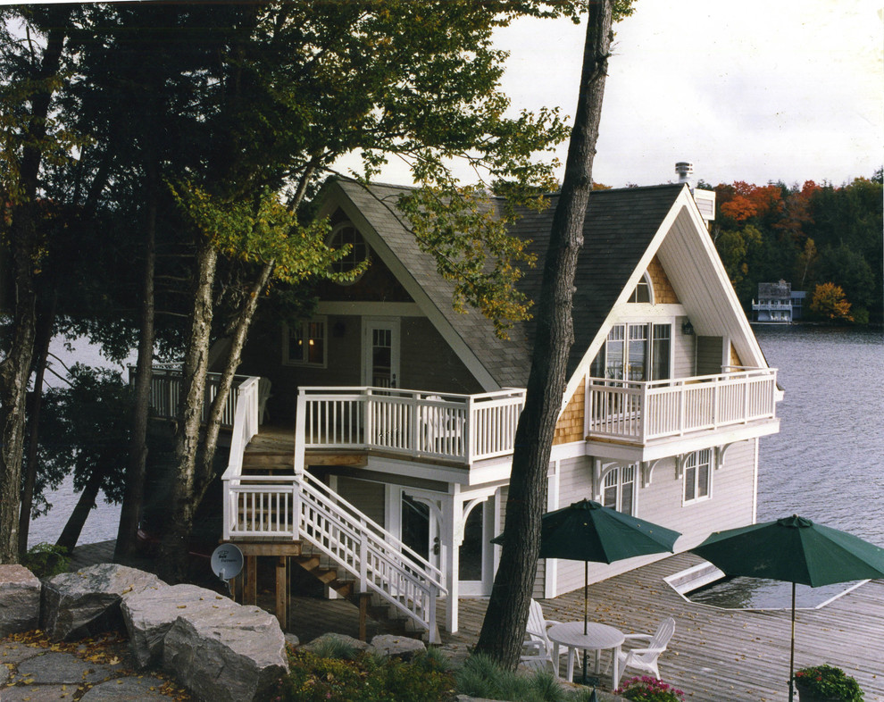Diseño de fachada de casa multicolor costera grande de dos plantas con revestimiento de madera, tejado a dos aguas y tejado de teja de madera