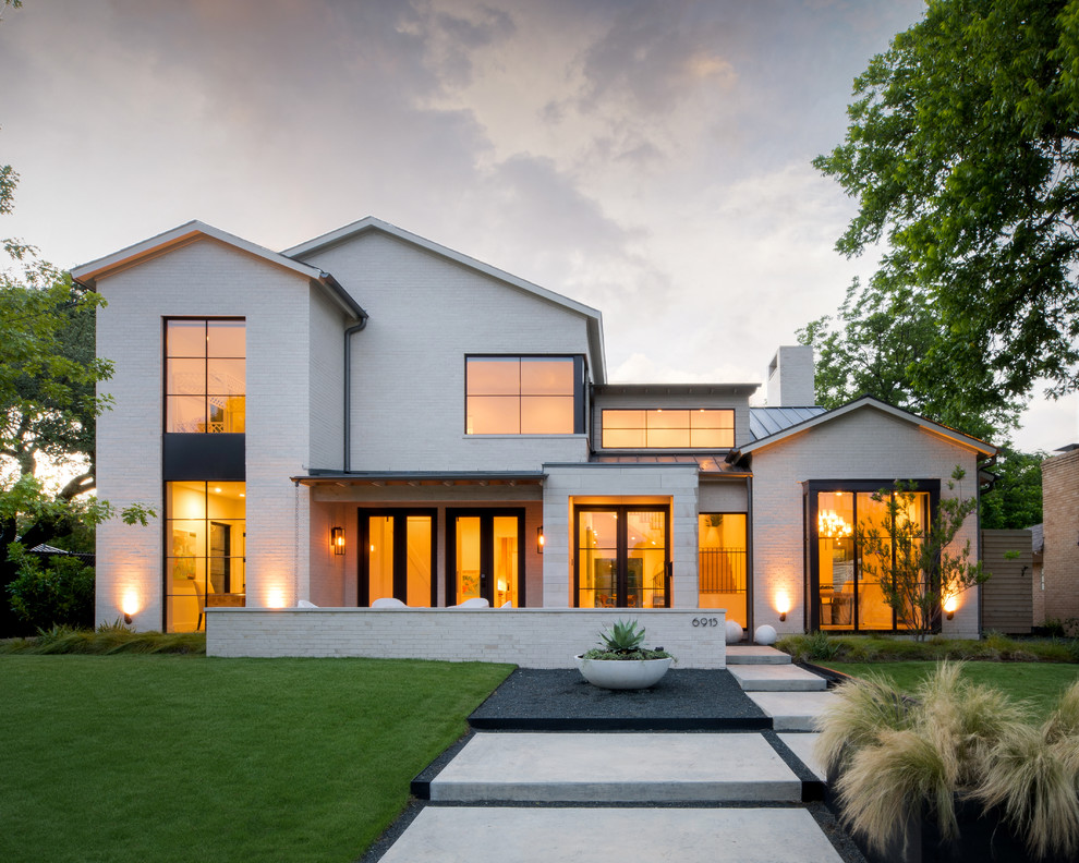 Стильный дизайн: двухэтажный, белый, большой частный загородный дом в современном стиле с облицовкой из камня, двускатной крышей и металлической крышей - последний тренд