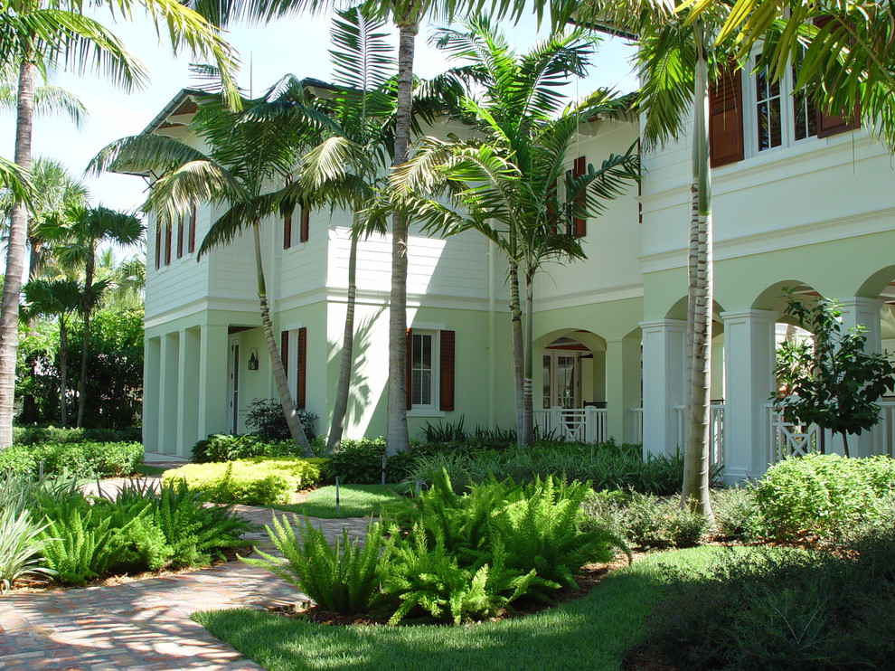 Imagen de fachada de casa multicolor exótica grande de dos plantas con revestimientos combinados y tejado de teja de barro