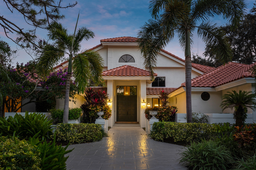 Zweistöckiges Mediterranes Einfamilienhaus mit weißer Fassadenfarbe, Walmdach und Ziegeldach in Miami