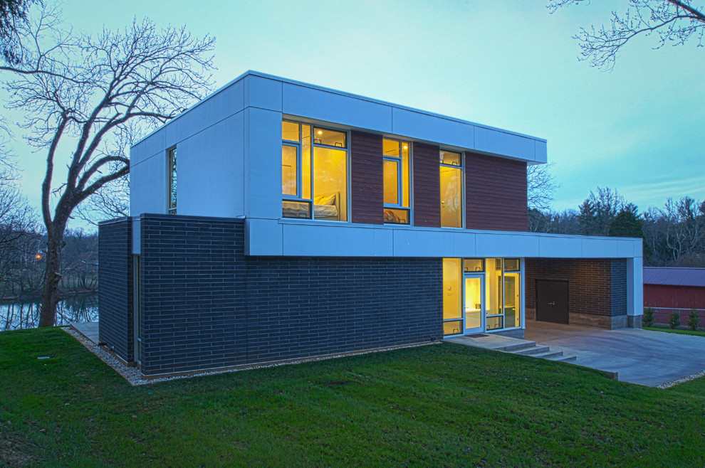 Example of a mid-sized minimalist gray two-story brick exterior home design in Other