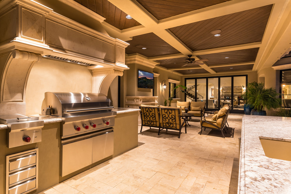 Example of a huge tuscan backyard stone patio kitchen design in Phoenix with a roof extension