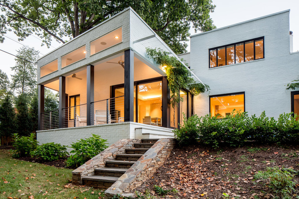 Diseño de fachada de casa blanca contemporánea grande de dos plantas con revestimiento de ladrillo y tejado plano