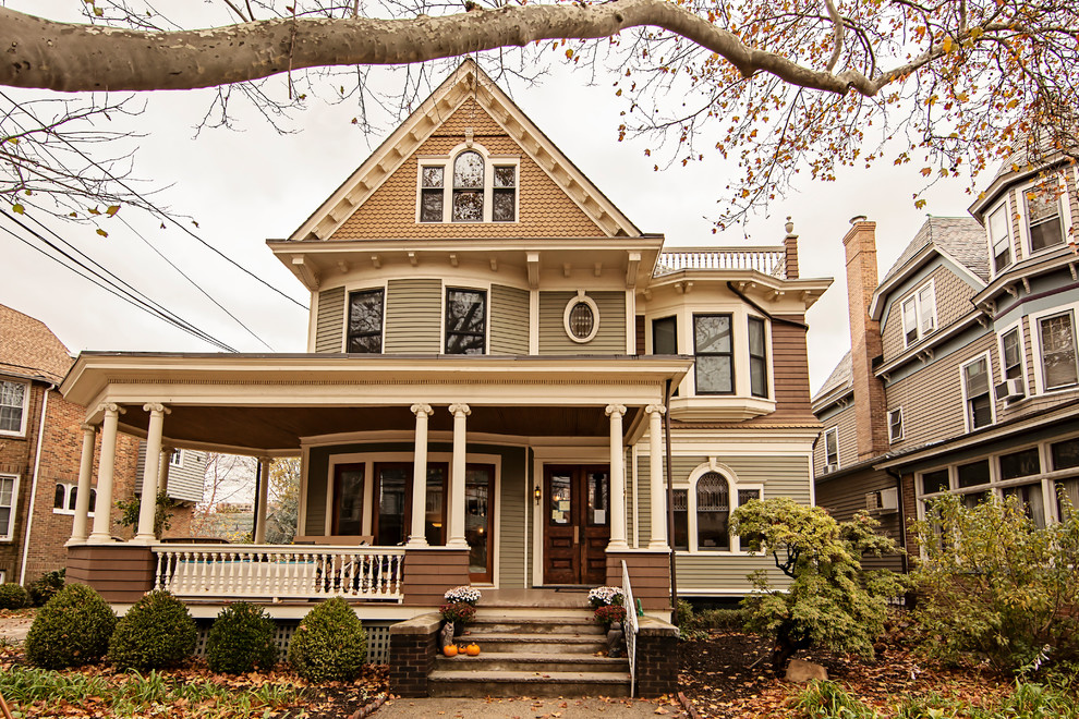 Inspiration for a large victorian beige three-story mixed siding exterior home remodel in Other with a shingle roof