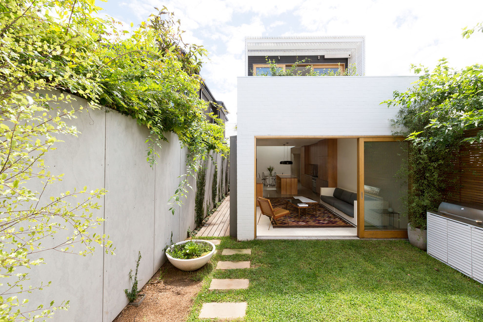 Réalisation d'une petite façade de maison blanche minimaliste en bois à un étage avec un toit plat.