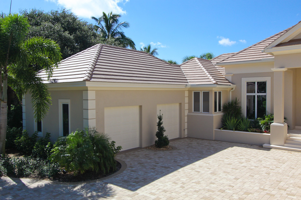 Ejemplo de fachada de casa beige mediterránea de dos plantas con revestimiento de estuco, tejado a dos aguas y tejado de teja de barro