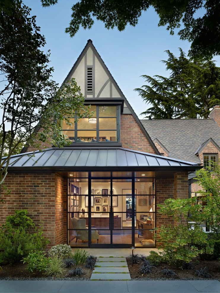 Пример оригинального дизайна: кирпичный дом в классическом стиле с двускатной крышей и крышей из смешанных материалов