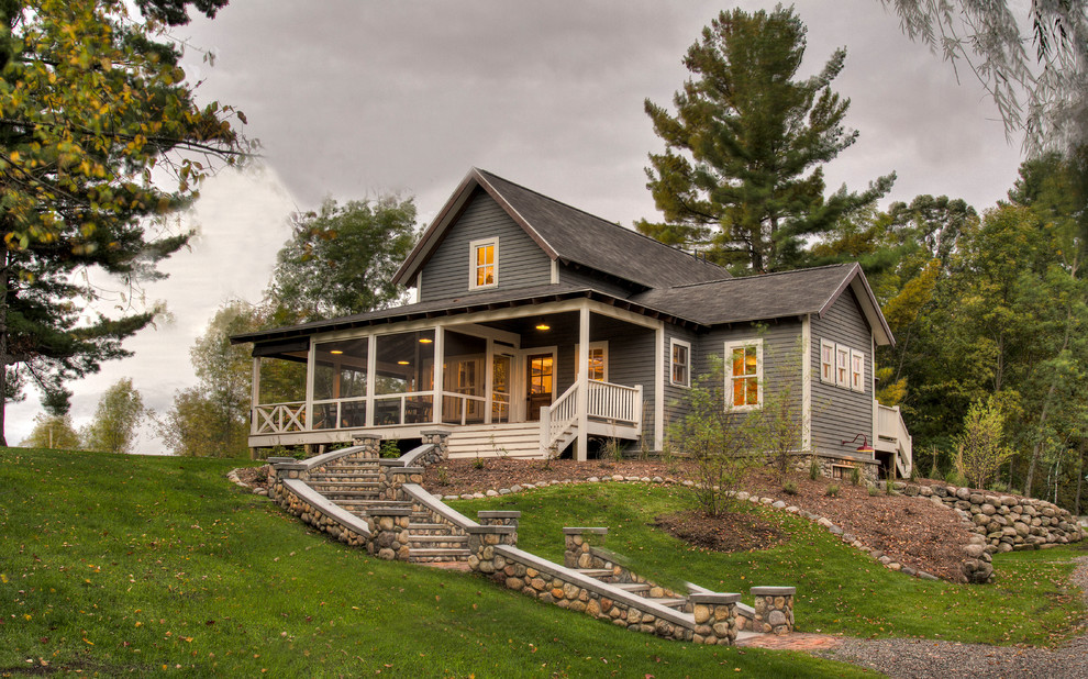 Modelo de fachada de casa gris de estilo de casa de campo de tamaño medio de dos plantas con revestimiento de vinilo, tejado de teja de madera y tejado a dos aguas