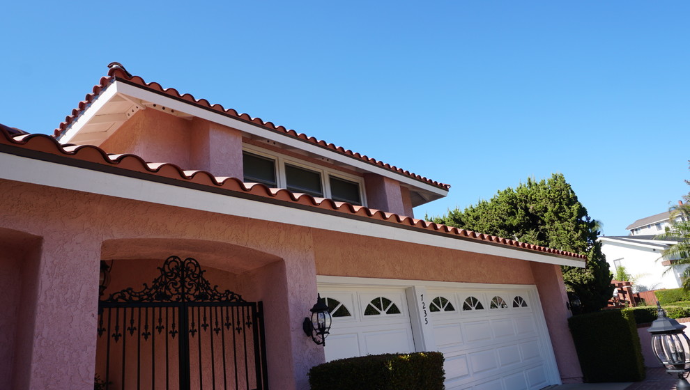 Ejemplo de fachada de casa beige mediterránea de tamaño medio de dos plantas con revestimiento de estuco, tejado a dos aguas y tejado de teja de barro