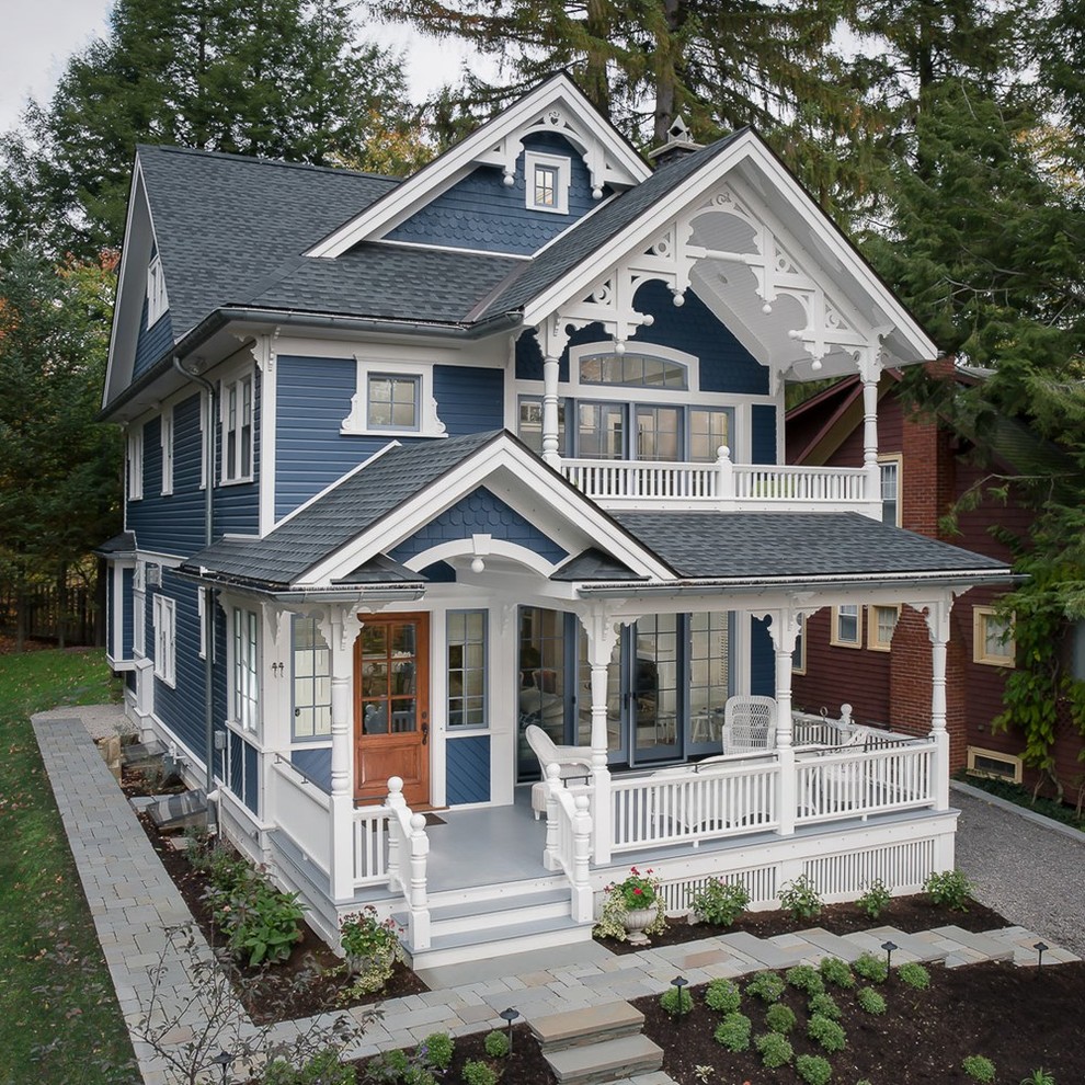 Идея дизайна: двухэтажный, синий частный загородный дом в викторианском стиле с двускатной крышей и крышей из гибкой черепицы