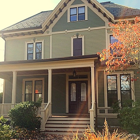 This is an example of a large and green victorian two floor house exterior in Boston with wood cladding.