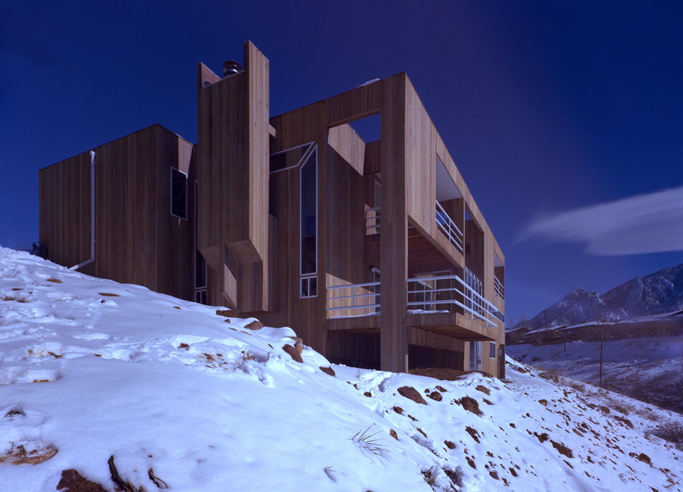 Immagine della facciata di una casa grande beige moderna a tre piani con rivestimento in legno e tetto piano