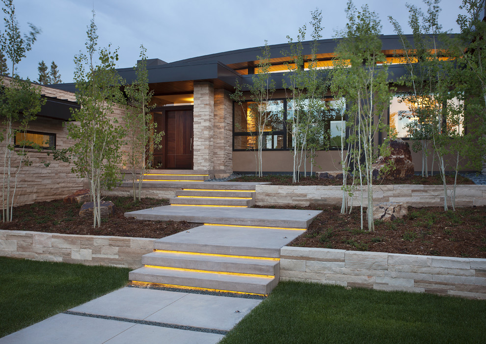 Example of a trendy beige two-story stone exterior home design in Denver